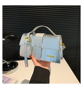 Detailed shot of silver metallic leather handbag with gold JINGPIN logo and strap