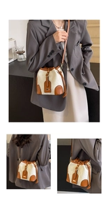 Detail der Kontrast-Eimertasche mit Metallschnalle und abgesteppten Nähten im Fokus