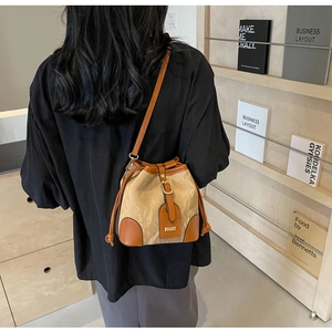 Detailansicht der Kontrastnähte und des braunen Lederbesatzes an der Bucket Bag