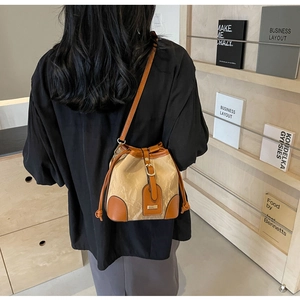 Detail der Kontrast-Beuteltasche mit Knitter-Textur und Lederriemen am Model gezeigt