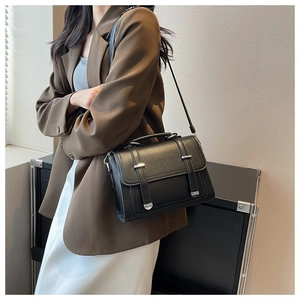 Detail view of black lychee leather crossbody bag with silver hardware and adjustable strap