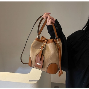 Detail der Kontrast-Beuteltasche mit beigem Cloud-Stoff und braunem Lederbesatz im Fokus