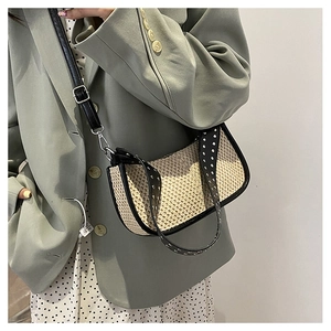 Détail du sac à bandoulière tissé avec sangle en cuir noir et rivets argentés