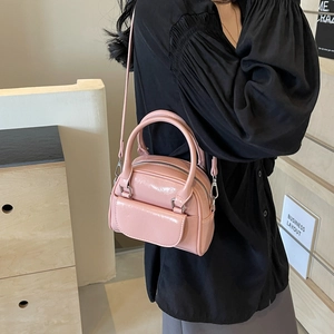 Pink patent leather mini shell bag with dual handles and crossbody strap