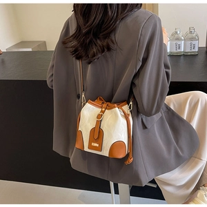 Detail der Bucket Bag in Color-Block-Design mit cremefarbener Struktur und braunem Leder