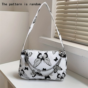 Detail of white canvas shoulder bag featuring random butterfly prints and silver metal chain