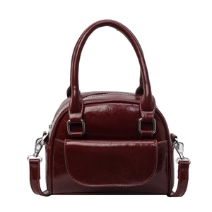 Glossy burgundy shell bag in vintage leather style with handles and shoulder strap