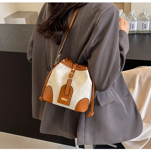 Detail der Kontrastnähte und Goldschnallen einer zweifarbigen Bucket Bag als Umhängetasche