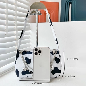 Detail view of cow print canvas underarm bag with dimensions 20x12x8cm and chain