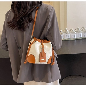 Detail einer Kontrast-Beuteltasche mit Karamell-Besatz getragen zum Blazer