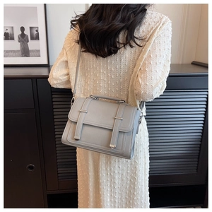 Rear view of model wearing a chic grey PU leather messenger bag with adjustable strap