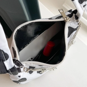 Top view of cow print canvas underarm bag showing interior space for phone and lipstick