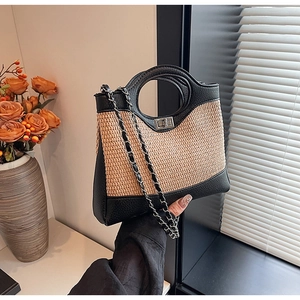 Détail du sac seau bicolore avec poignées en cuir et fermoir rotatif métallique
