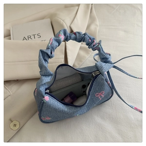Capacity view of floral denim handbag with pleated handle and pink bow prints