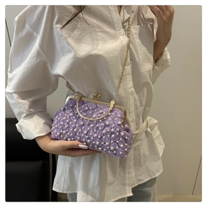 Close-up of purple 3D flower evening bag with pearl accents and gold metal chain