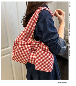 Detail of red and white gingham bow shoulder bag worn by model in casual style