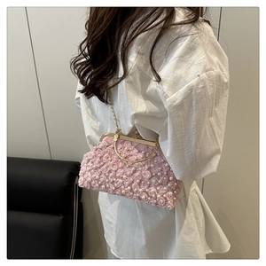 Dettaglio borsa rosa con rose 3D fatte a mano e manico ad anello in metallo dorato