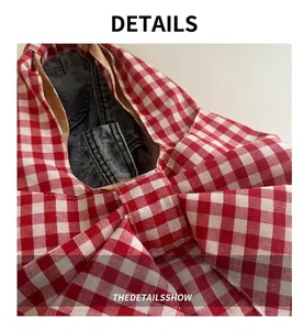 Close-up of a large red and white checkered bow detail on a spacious tote bag