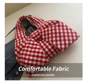 Detail of red and white checkered canvas tote bag featuring a large decorative bow design