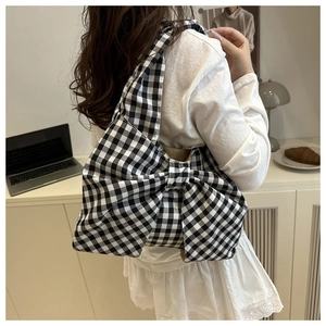 Close-up of black and white plaid canvas tote bag with a large decorative bow