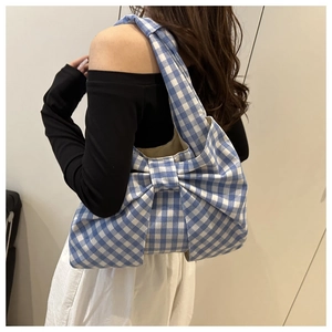 Detail of blue and white gingham tote bag featuring a decorative oversized bow design