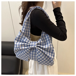 Vista indossata di una borsa tote a scacchi blu e bianchi con un grande fiocco