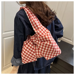 Détail du grand sac cabas à carreaux rouges et blancs en forme de nœud sur un mannequin