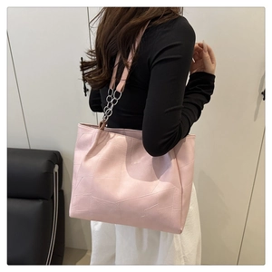 Detail of pink faux leather tote bag with geometric stitching and silver metal chain strap
