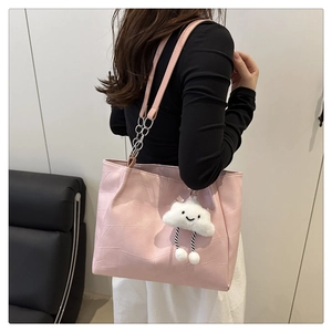 Detail view of pink tote bag featuring geometric texture, chain strap, and cloud charm