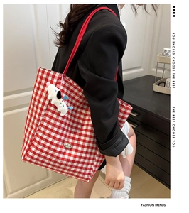 Detail van rood geblokte canvas shopper met handgemaakt label en pluche puppy hanger