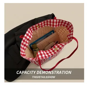 Detailed interior view of red checkered canvas tote bag showing large capacity and magnetic buckle