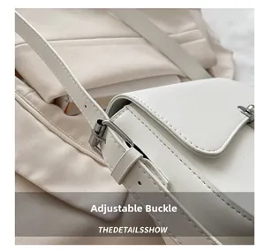 Close-up of adjustable silver buckle and premium stitching on a white shoulder bag