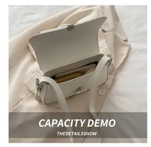 Internal capacity of the white leather shoulder bag showing space for phone and wallet