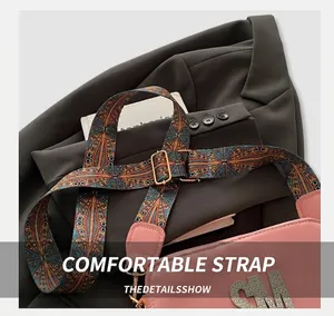 Detailed view of the wide jacquard strap with geometric patterns on a pink crossbody bag
