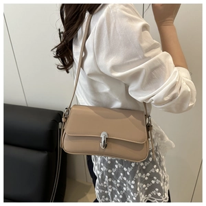 Minimalist beige crossbody bag with silver buckle shown on shoulder for a trendy summer look