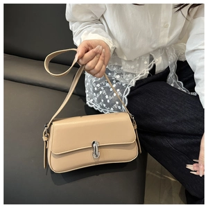 Detail of beige leather shoulder bag featuring a rectangular silver metal buckle and strap