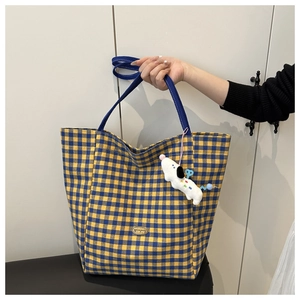 Détail du sac cabas à carreaux avec anses bleues et pendentif chien en peluche