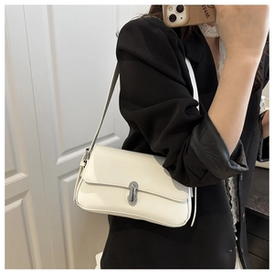 Detail of white leather shoulder bag with silver oval twist lock on minimalist flap