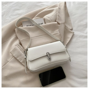 Detailed view of a white minimalist leather shoulder bag with a silver buckle clasp