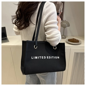 Black canvas tote bag with Limited Edition text shown in a stylish lifestyle setting