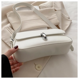 Detail view of cream leather shoulder bag featuring a polished silver oval metal twist lock