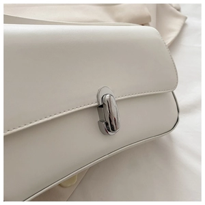 Close-up of minimalist white faux leather bag featuring a silver metal twist lock buckle