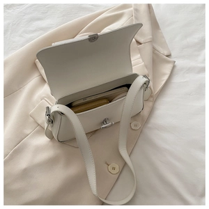 Internal view of a white leather underarm bag showing capacity for phone and wallet