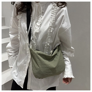 Detail of green waterproof nylon crossbody bag with adjustable strap and zipper closure
