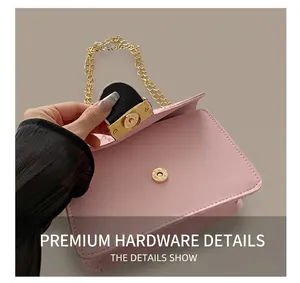 Detailed macro view of the golden metal twist lock on a pink PU leather handbag