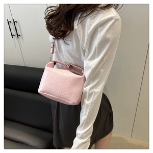 Close-up of pink pleated pillow bag with delicate vertical textures and gold hardware