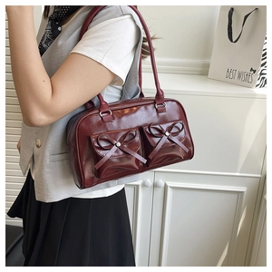 Side view of model wearing a vintage wine red leather underarm bag with bow pockets