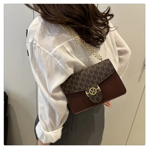 Detail of contrast color crossbody bag with gold M-logo buckle and chain strap