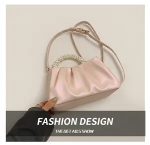 Dettaglio del manico in perle e del design a pieghe della borsa a nuvola in ecopelle rosa