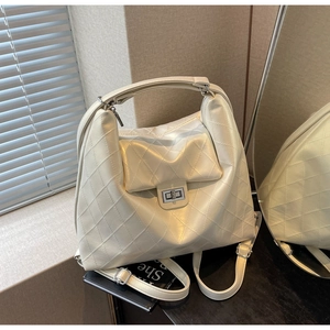 Détail du sac fourre-tout matelassé crème avec de grandes surpiqûres et un fermoir rotatif